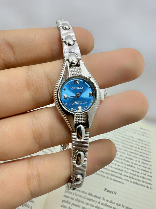 Reloj plateado con fondo azul