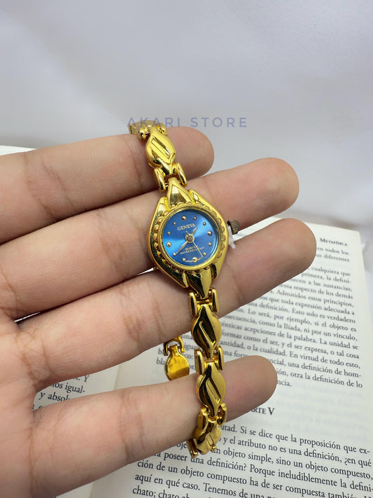 Reloj dorado minimalista con fondo azul