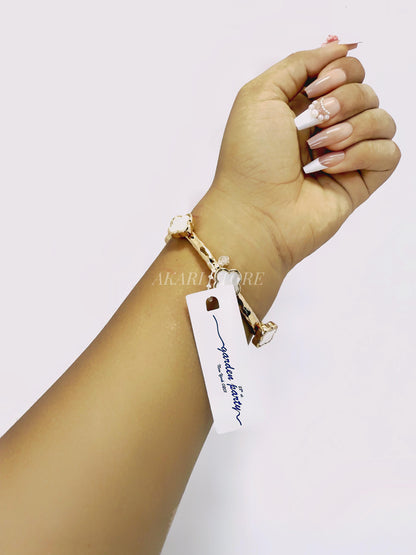 Brazalete dorado con dijes de trébol blanco