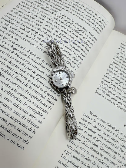 Reloj plateado de flor con dije de corazón