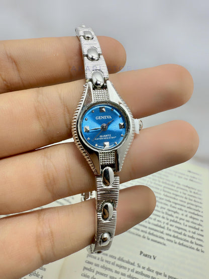 Reloj plateado con fondo azul