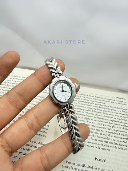 Reloj plateado en forma de flor
