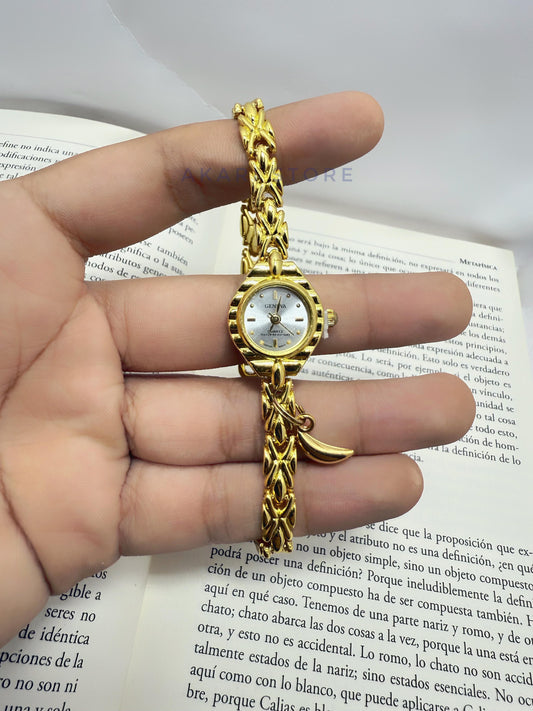 Reloj dorado con dije de luna