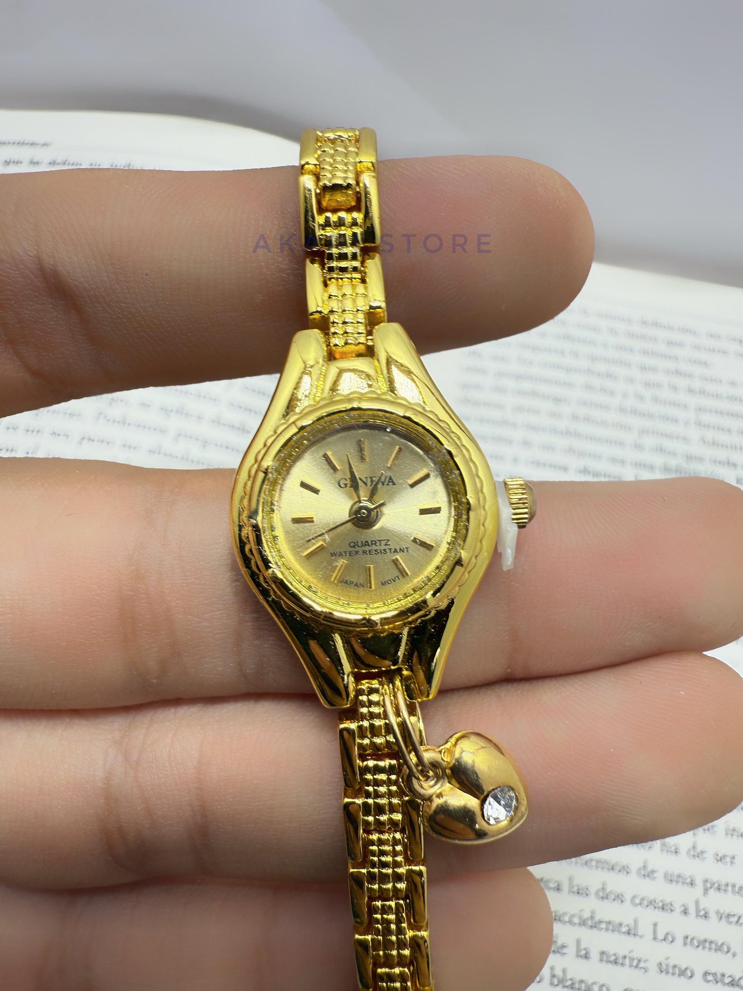Reloj dorado con dije de corazón