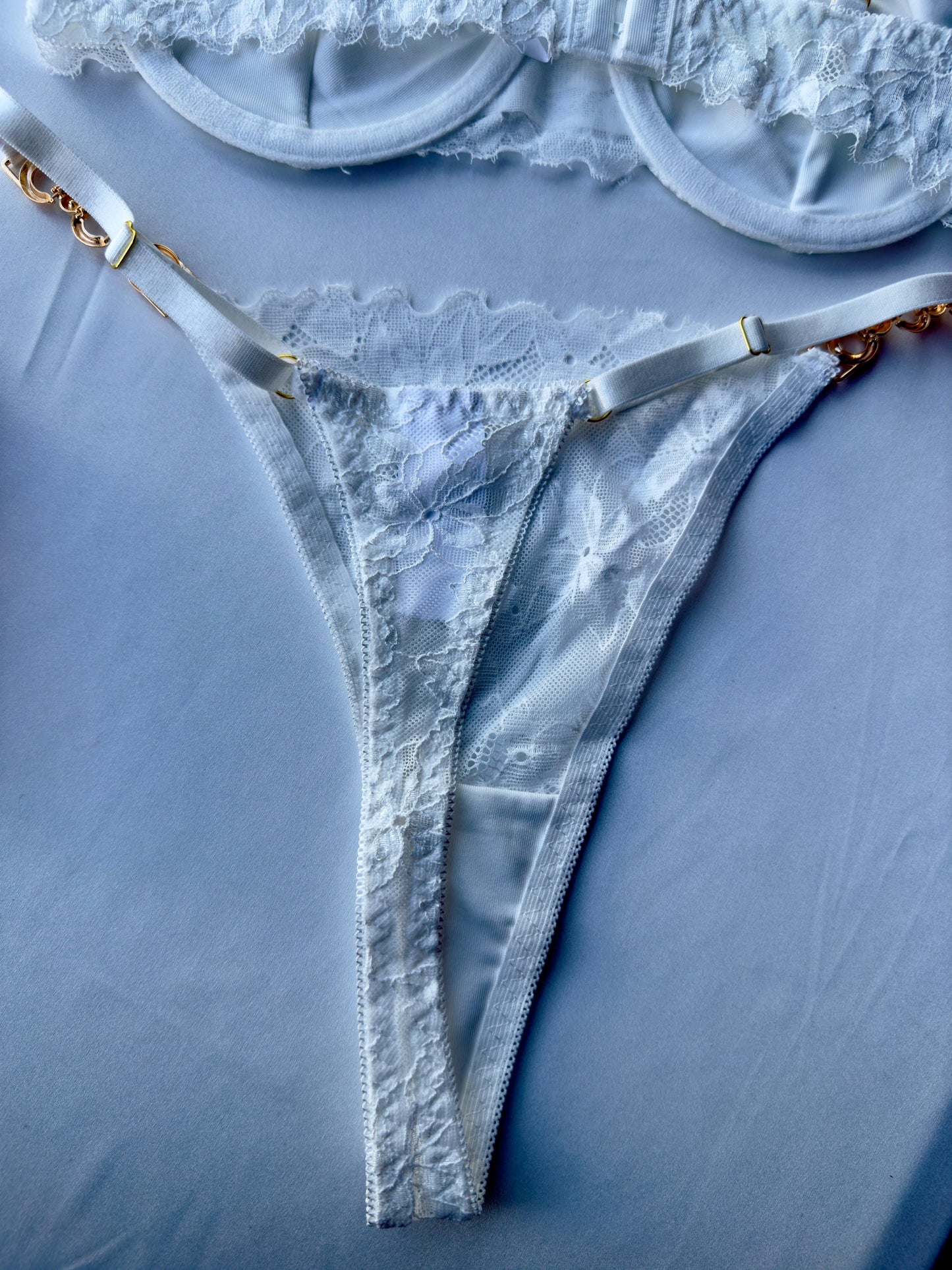 Lencería blanco con sujetador y braguita con aros y detalles de encaje floral y cadena